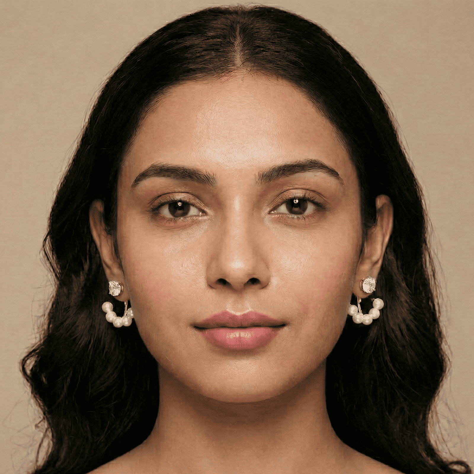 Woman wearing pearl stud and pearl jacket earrings combo