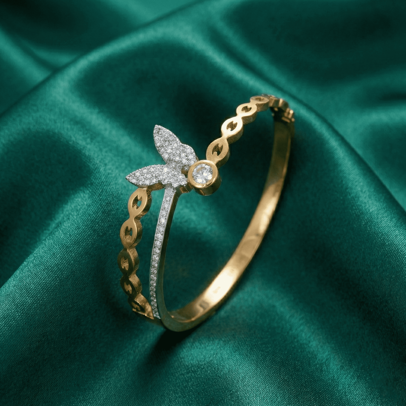 Side view of Eshanarya butterfly stainless steel bracelet for women on green satin cloth