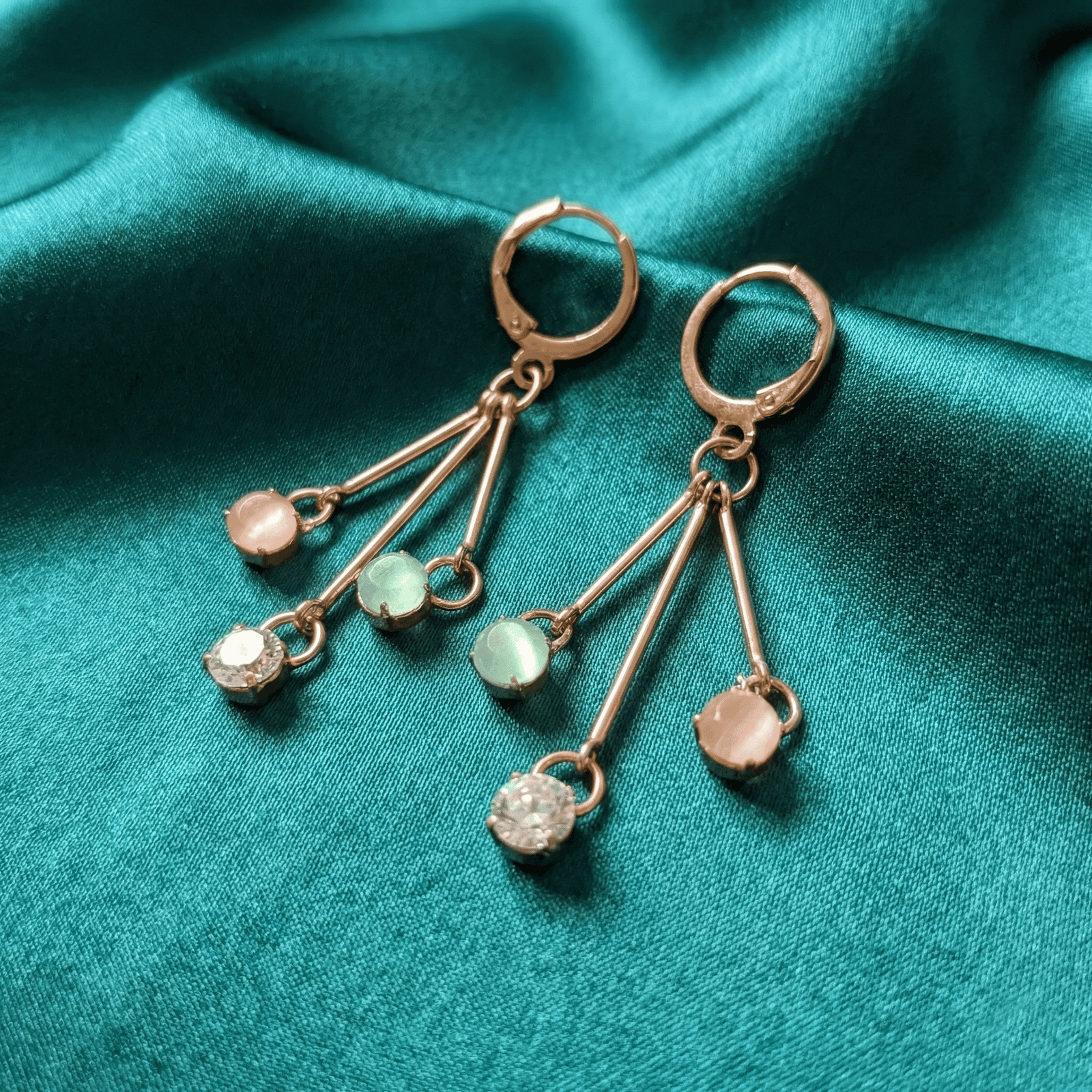 Minimal pastel crystal hoop earrings for women on satin background