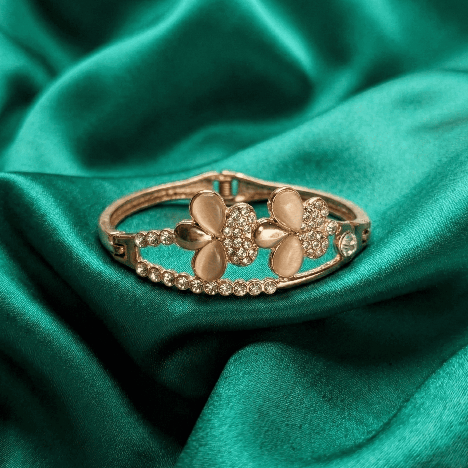 Eshanarya gold tone floral crystal bracelet for women on green satin fabric