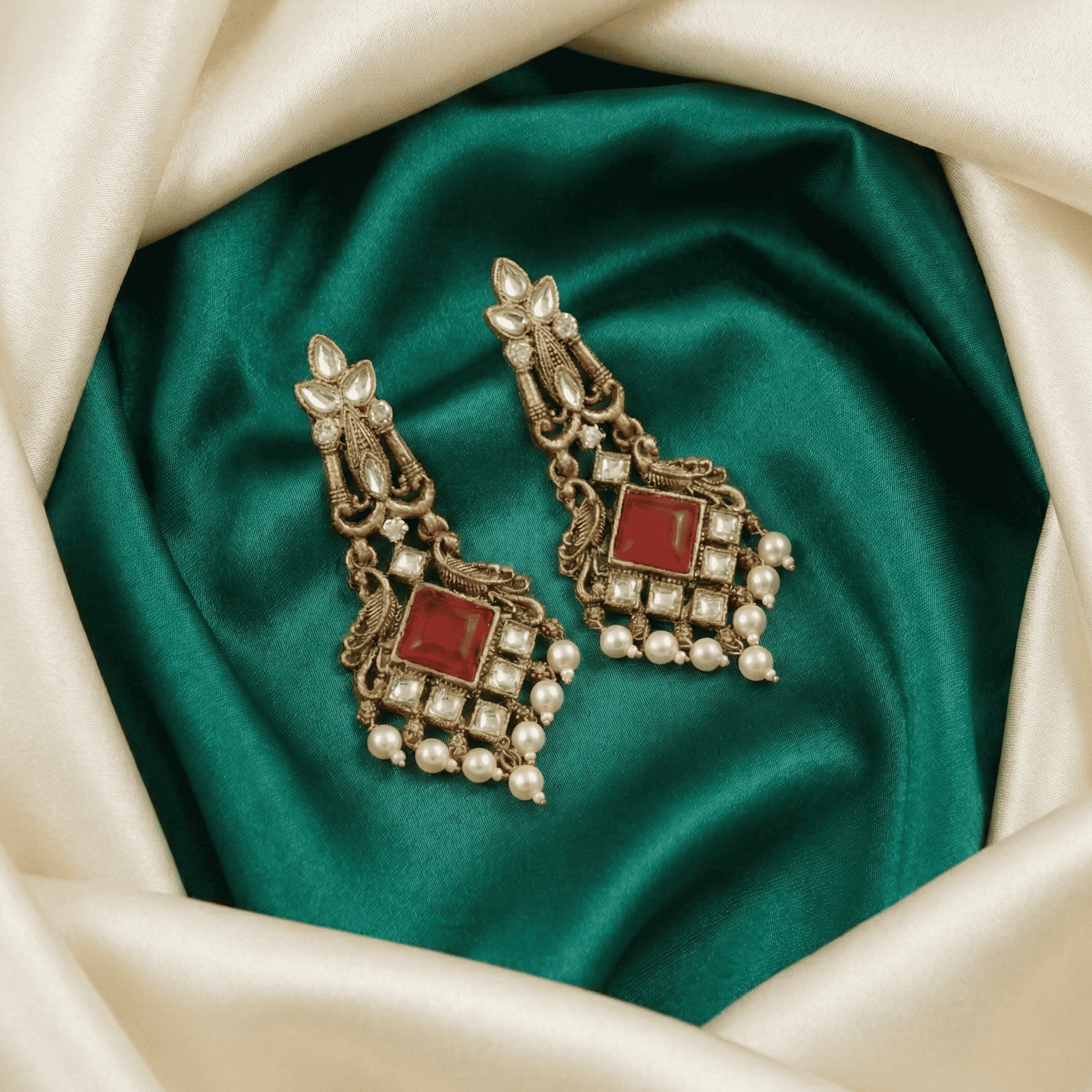 Antique gold chandelier earrings featuring red square stone and pearl drop detailing