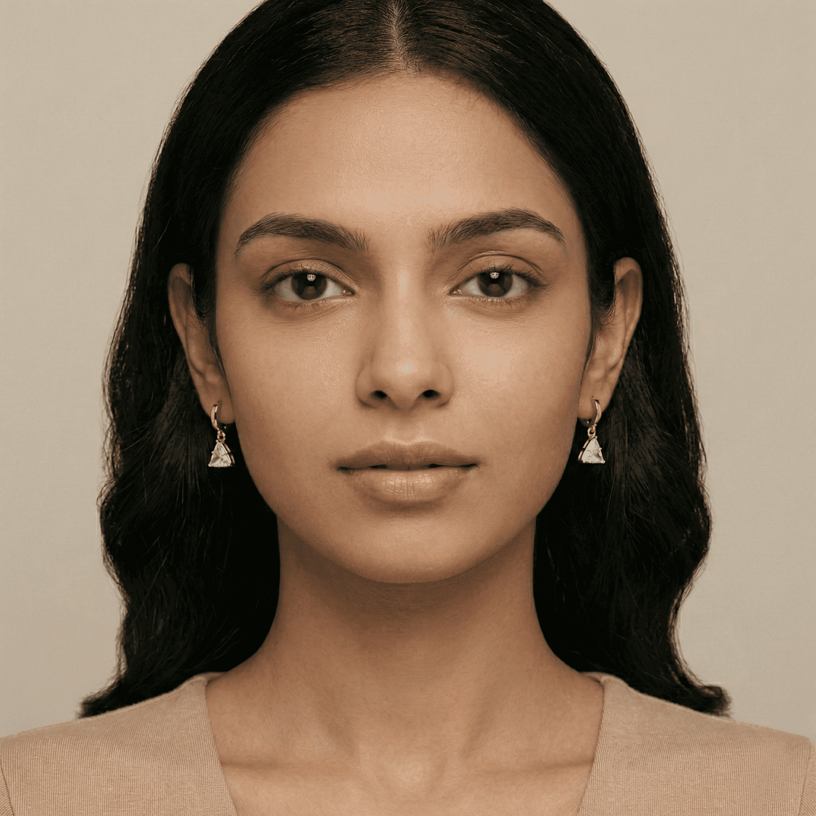 Woman wearing gold tone triangle earrings front view