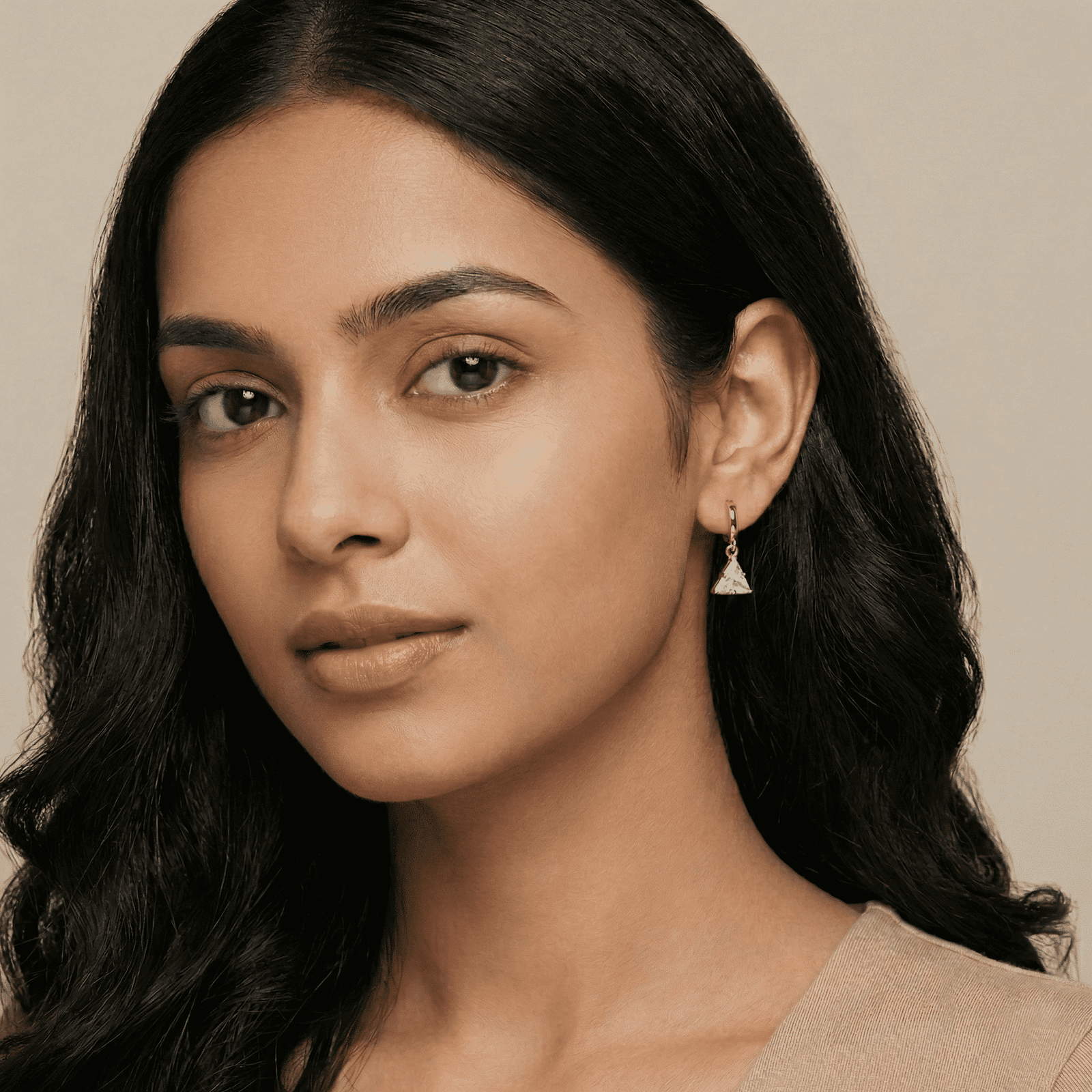 Side profile of woman wearing crystal triangle drop earrings