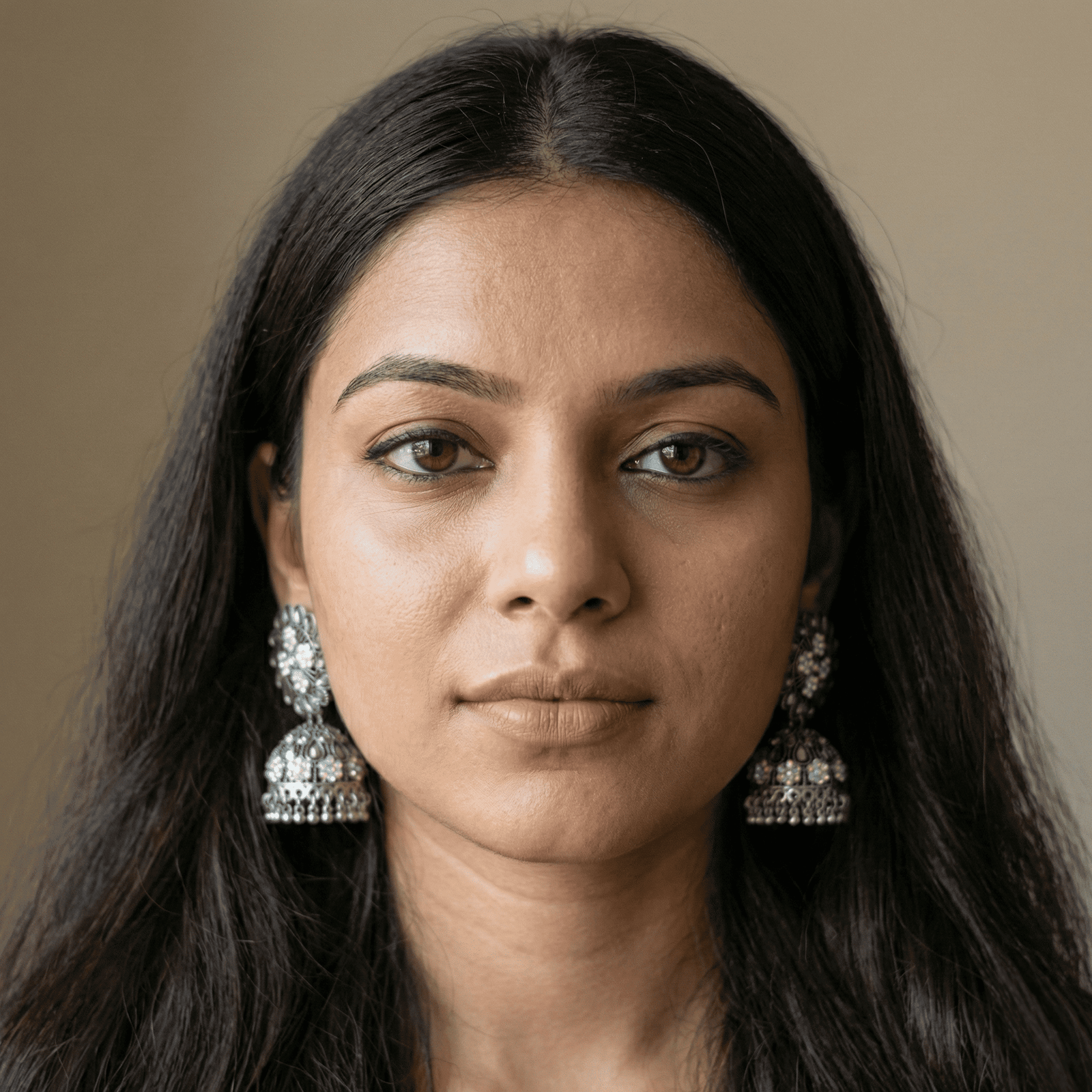 Woman wearing oxidised floral jhumka earrings with clear stones