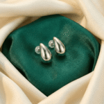 Modern silver teardrop earrings on satin fabric
