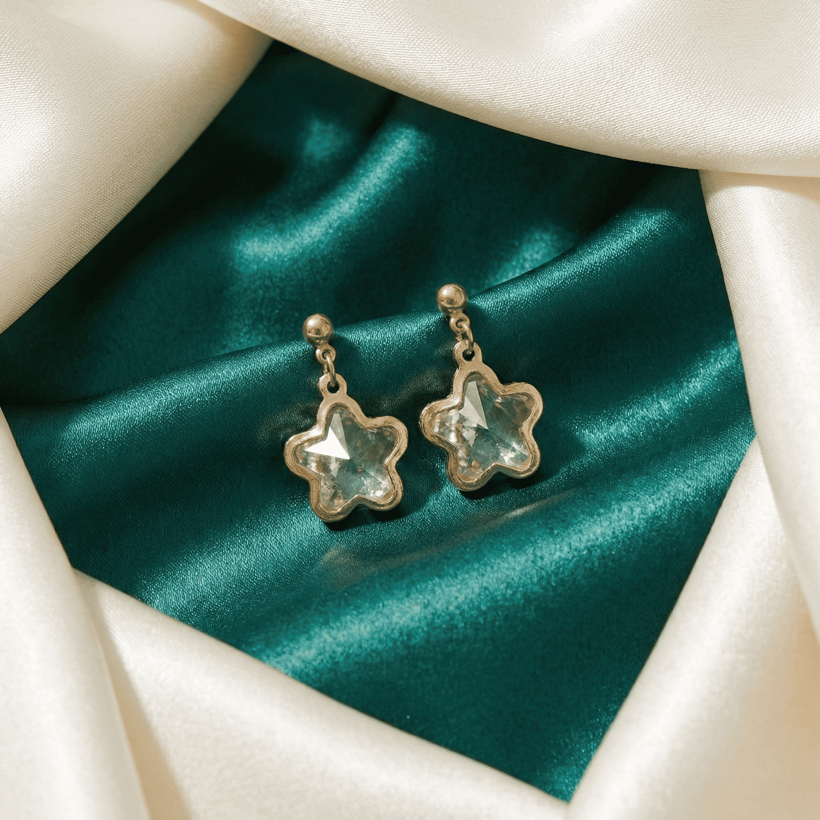 Contemporary star crystal drop earrings on satin background for party wear styling