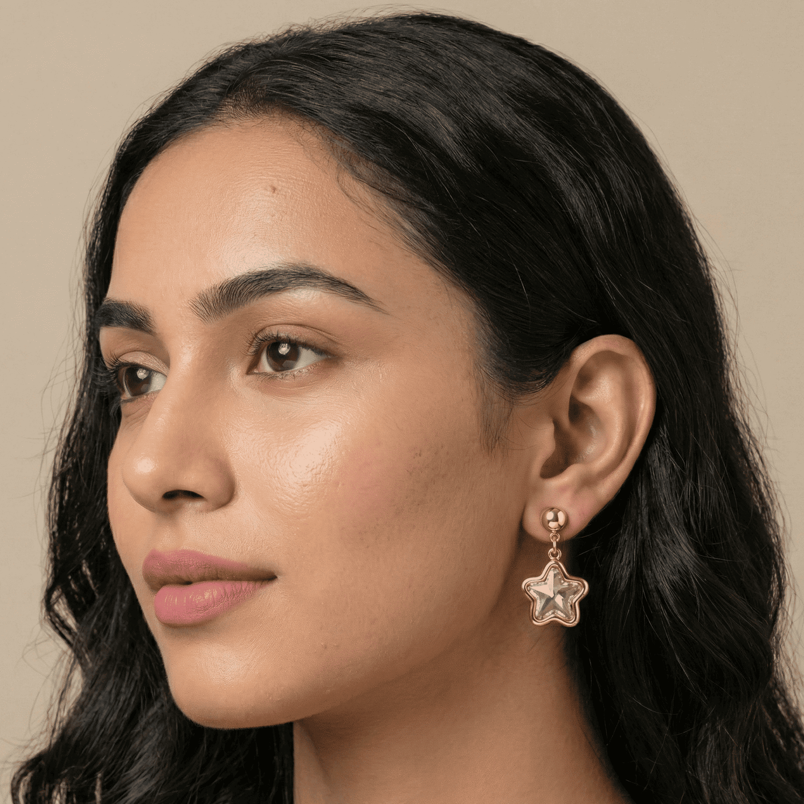 Woman wearing Eshanarya star shape crystal drop earrings with gold tone stud design
