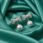 Pearl bow drop earrings for women on satin background