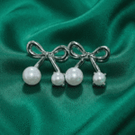 Pearl ribbon stud earrings with dual pearl accents