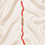Triple Crystal Floral Designer Rakhi for Brother with gold-tone floral crystal motifs and red thread on satin background