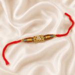 Eshanarya Mahakal Rudraksha Designer Rakhi with crystal Mahakal motif, Rudraksha-inspired beads and red thread on satin background