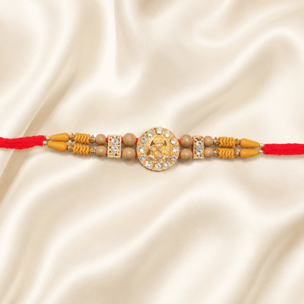 Eshanarya Lord Ganesha Crystal Designer Rakhi with wooden beads and red cotton thread on blue satin background