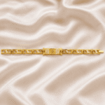 Eshanarya Om Bracelet Rakhi with crystal-studded Om centrepiece, gold finish bracelet links and minimalist design on satin background