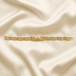 Eshanarya Jai Mata Di Gold Finish Bracelet Rakhi with crystal accents and rectangular engraved centrepiece displayed on an off-white satin background.