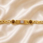 Eshanarya Om Rudraksha Gold Finish Bracelet Rakhi with silver Om centerpiece, dual Rudraksha beads and crystal link design on an off-white satin background.