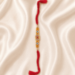 Eshanarya Divine Swastik Crystal Designer Rakhi for Brother front view on off white satin cloth