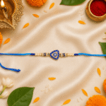Premium Blue Evil Eye Designer Rakhi on a festive setup with marigold flowers, diya, kumkum and traditional Raksha Bandhan décor.