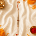 Premium festive display of Eshanarya Regal Ruby Bracelet Rakhi with marigold flowers, diya and kumkum