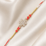 Angled view of Eshanarya Red Crystal Designer Rakhi with sparkling snowflake centrepiece