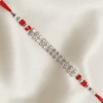 Angled close-up of handcrafted crystal designer Rakhi on soft satin cloth