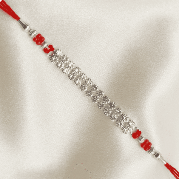 Angled close-up of handcrafted crystal designer Rakhi on soft satin cloth