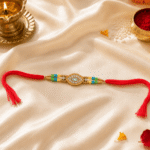 Luxury festive display of handcrafted designer Rakhi on satin cloth with diya, kumkum, and floral decorations