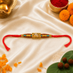Flat lay of Mahakal Rudraksha Rakhi on satin background with traditional Raksha Bandhan decorations