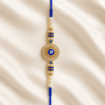 Close-up of Blue Evil Eye Designer Rakhi with crystal border, gold-tone finish and pearl bead detailing
