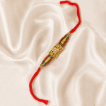 Angled view of Mahakal Rudraksha Designer Rakhi featuring gold-tone Mahakal centrepiece and crystal detailing