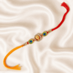 Top view of Lord Ganesha Crystal Designer Rakhi with peacock feather accents and dual-colour thread