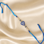 Premium Blue Evil Eye Triangle Designer Rakhi showcasing a triangular Nazar charm with crystal stones and decorative pearl accents.