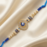 Close-up of Blue Hamsa Evil Eye Designer Rakhi showcasing an oval Nazar charm with crystal embellishments and pearl accents.