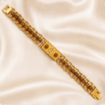 Premium Om bracelet rakhi with rudraksha beads and gold-tone chain displayed diagonally on soft satin fabric