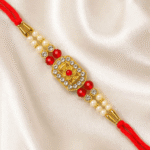 Angled view of premium crystal rakhi featuring floral centerpiece, pearls, and red beads