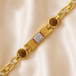 Angled close-up of Eshanarya Gold Finish Om Bracelet Rakhi with dual Rudraksha beads, engraved detailing and crystal-accented bracelet links.