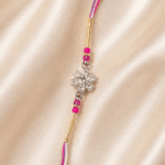 Close-up of crystal flower motif with pink decorative beads on designer rakhi
