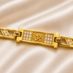 Macro close-up of Eshanarya Om Bracelet Rakhi highlighting the crystal-studded Om motif and polished gold finish