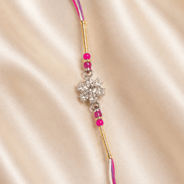 Detailed crystal floral centrepiece of Eshanarya Pink Designer Rakhi with pink thread