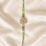 Close-up vertical image of green crystal designer Rakhi with decorative pearl and golden beads