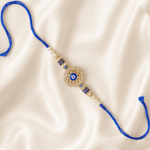 Designer Evil Eye Rakhi with blue enamel detailing, pearl beads and crystal stone border for festive gifting