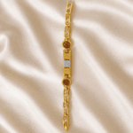 Vertical display of Eshanarya Om Bracelet Rakhi featuring a silver Om symbol, Rudraksha beads and gold finish bracelet chain on satin fabric.