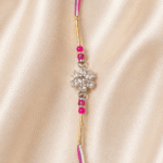 Premium Pink Crystal Flower Designer Rakhi displayed with festive diya, kumkum and marigold flowers