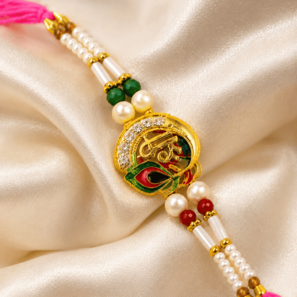 Premium Shree designer rakhi with pearl detailing displayed on green satin fabric