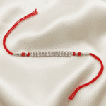 Premium crystal Rakhi with silver finish and traditional red thread displayed on satin background