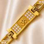 Close-up of Eshanarya Om Bracelet Rakhi featuring a raised Om symbol with sparkling crystal accents and gold finish