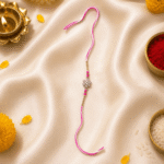 Luxury festive flat lay of Pink Crystal Flower Designer Rakhi with Raksha Bandhan decorations