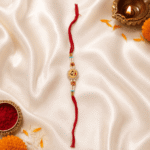 Premium Om Rakhi with crystal work and pearl beads arranged for Raksha Bandhan celebration on satin fabric