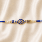 Close-up of Blue Nazar Designer Rakhi showcasing sparkling crystal stones, pearl beads and an evil eye charm for Raksha Bandhan gifting.