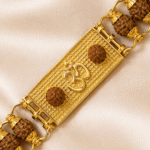 Close-up of spiritual Om bracelet rakhi with natural rudraksha beads and polished gold-tone bracelet links