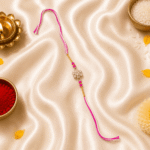 Close-up lifestyle image of Eshanarya Pink Crystal Flower Rakhi on festive satin background
